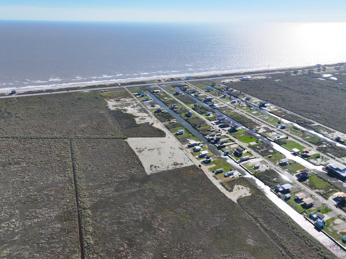 Aerial view of the Bolivar Peninsula shoreline, coastal homes, and surrounding land